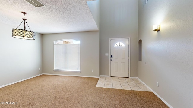 carpeted foyer with a textured ceiling