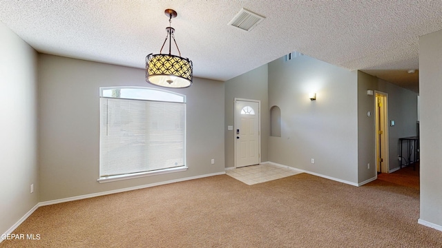 carpeted foyer entrance with a textured ceiling