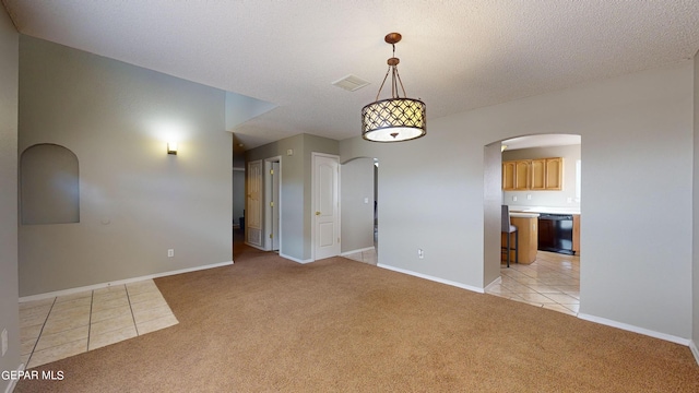 empty room featuring light colored carpet and a textured ceiling