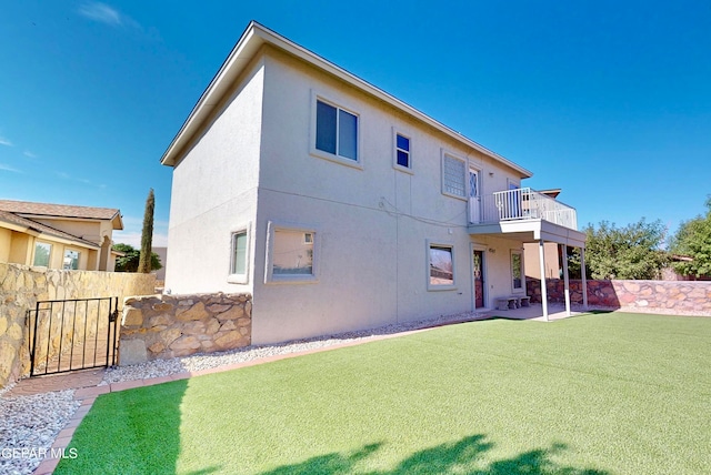 rear view of house with a patio and a lawn