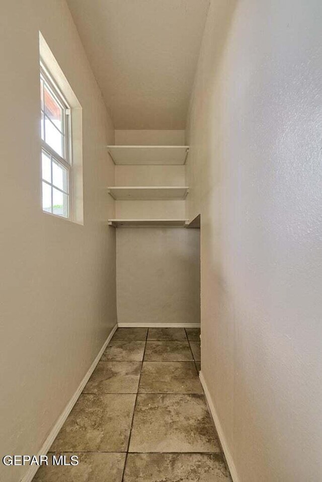 spacious closet featuring tile flooring