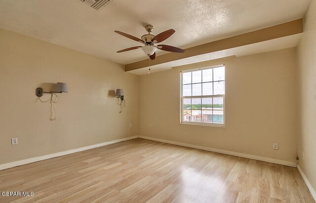 spare room with a textured ceiling, ceiling fan, and light hardwood / wood-style flooring