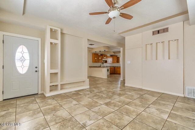 tiled foyer with ceiling fan