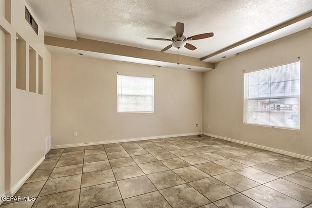 unfurnished room featuring a healthy amount of sunlight, tile flooring, ceiling fan, and a textured ceiling