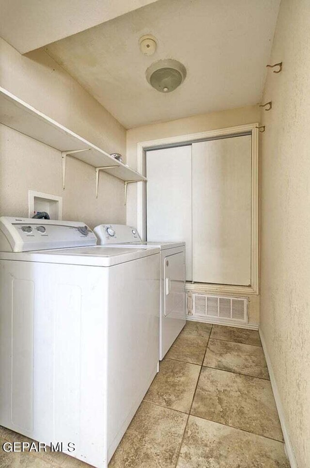 washroom with washer and clothes dryer, light tile floors, and hookup for a washing machine