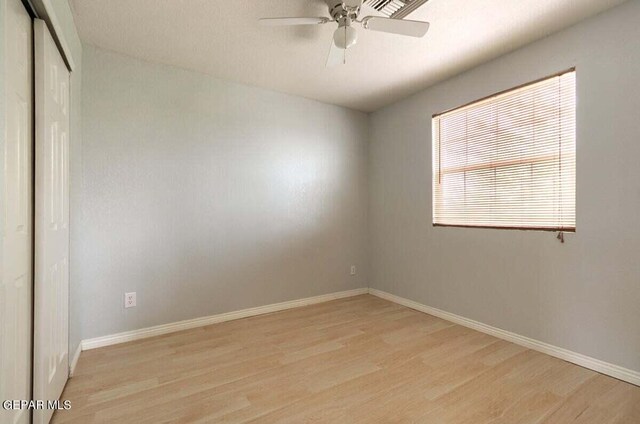 spare room with ceiling fan and light wood-type flooring