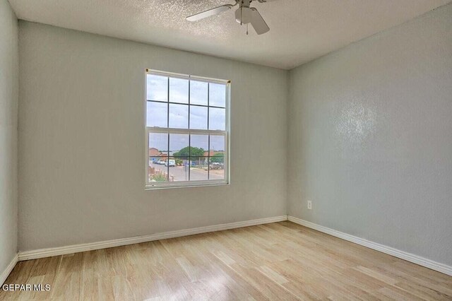 spare room featuring a textured ceiling, ceiling fan, and light wood-type flooring