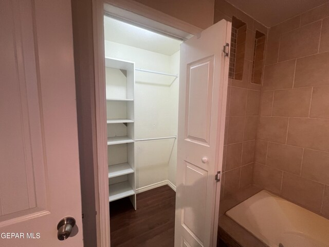 bathroom featuring tiled shower / bath and wood-type flooring