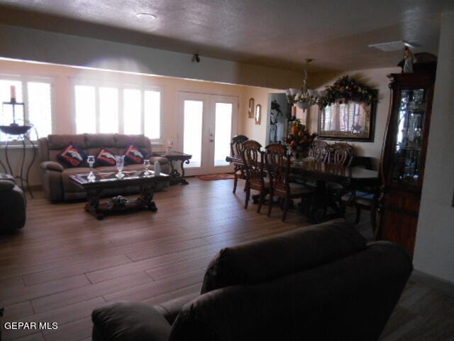 living room featuring a chandelier, french doors, hardwood / wood-style flooring, and a wealth of natural light