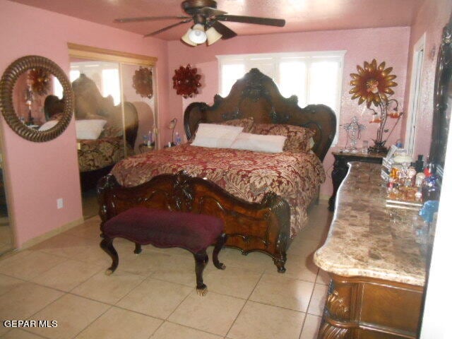 tiled bedroom featuring ceiling fan