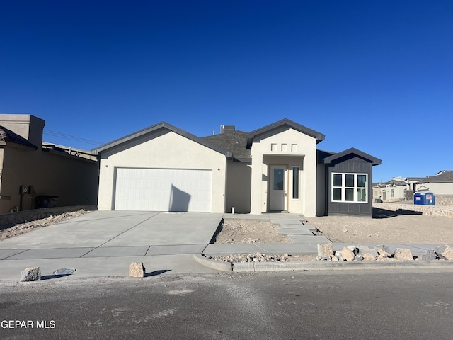 view of front of property with driveway, board and batten siding, an attached garage, and stucco siding