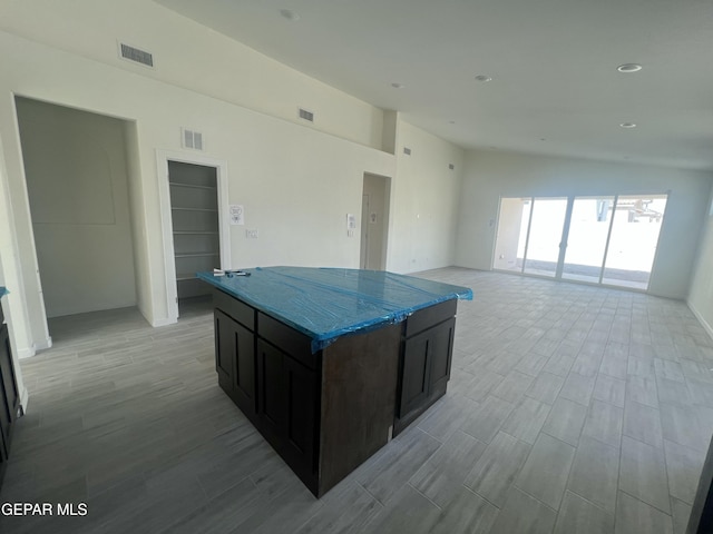 kitchen with stone countertops, visible vents, and a center island