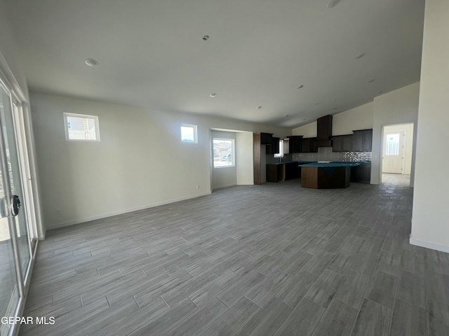 unfurnished living room with baseboards and wood finished floors