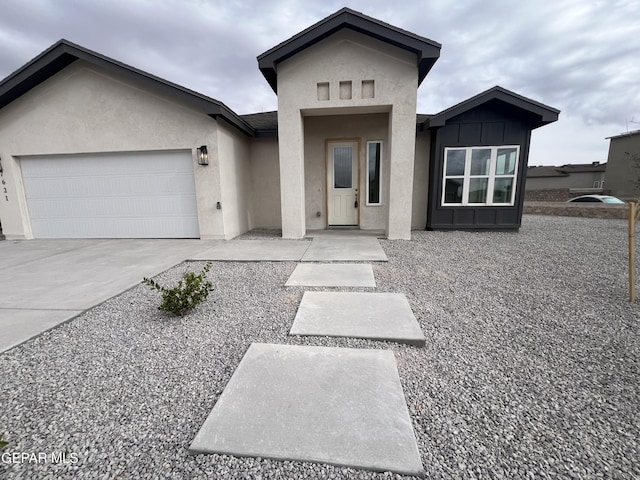 view of front of home with an attached garage, driveway, and stucco siding