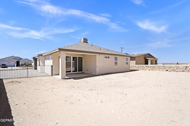back of house with fence, stucco siding, and a patio area