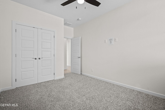 unfurnished bedroom with a closet, baseboards, a ceiling fan, and carpet floors