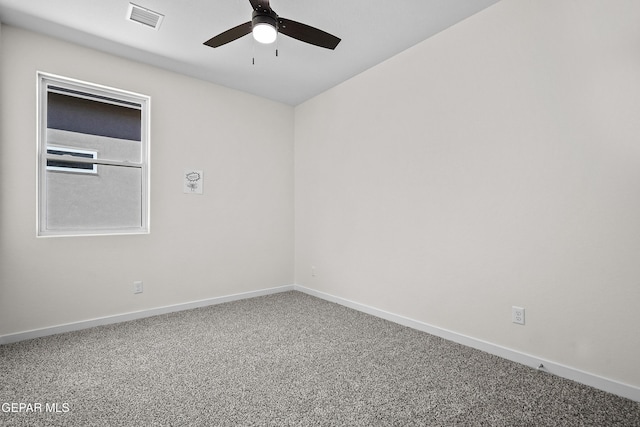 carpeted spare room with baseboards, visible vents, and a ceiling fan