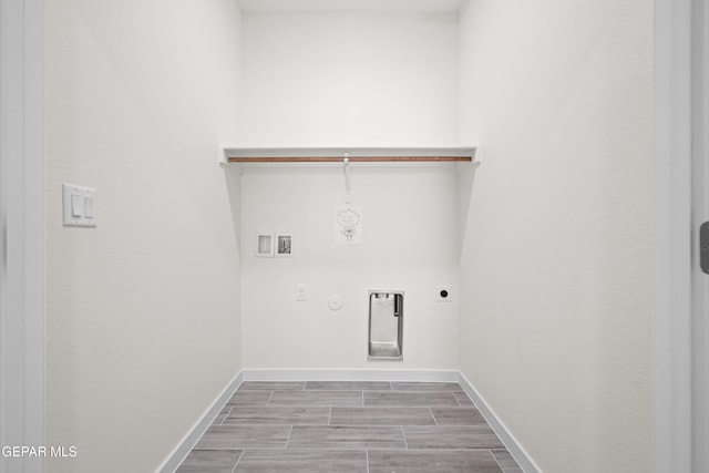 washroom with gas dryer hookup, electric dryer hookup, baseboards, wood finish floors, and laundry area