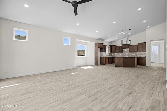 unfurnished living room featuring recessed lighting, ceiling fan, vaulted ceiling, and plenty of natural light