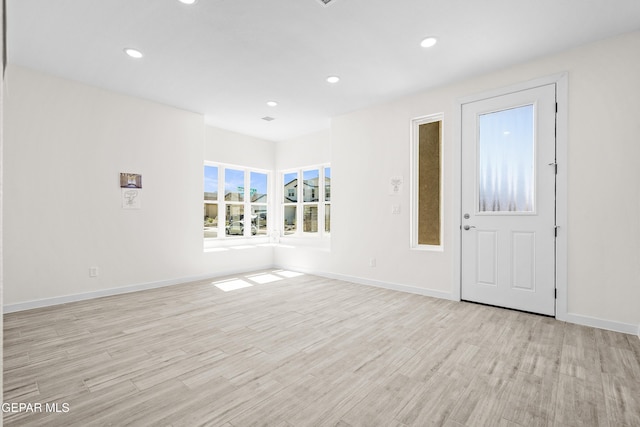 unfurnished living room featuring recessed lighting, light wood finished floors, and baseboards