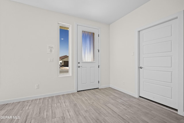foyer entrance featuring light wood-style flooring and baseboards