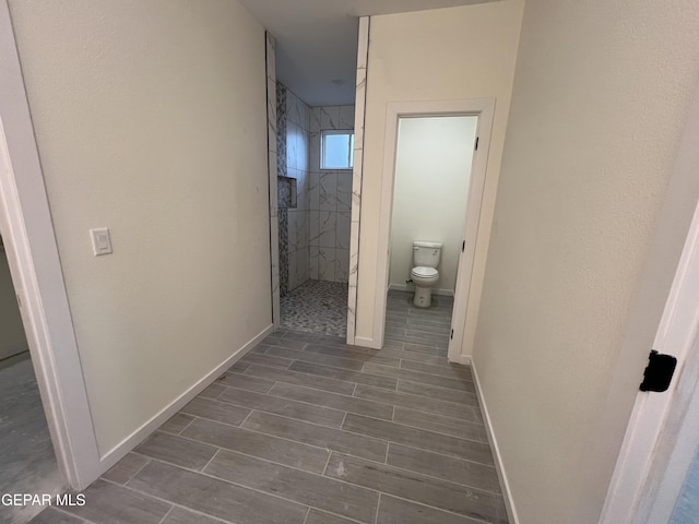 bathroom featuring toilet and tiled shower