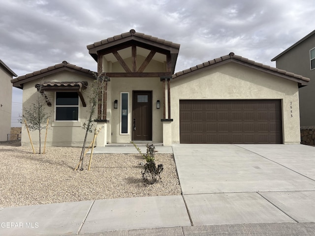 view of front facade featuring stucco siding, a garage, and concrete driveway