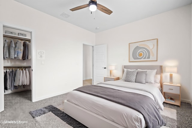 carpeted bedroom featuring a ceiling fan, baseboards, visible vents, and a spacious closet
