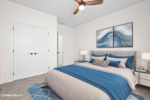 carpeted bedroom with a closet, a ceiling fan, and visible vents