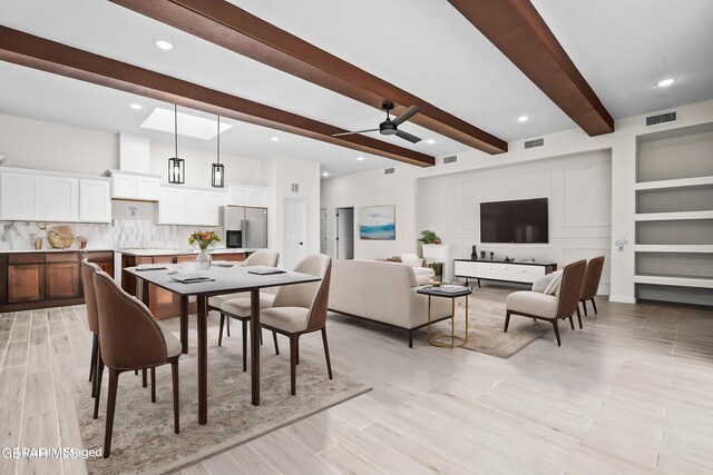 dining space with beamed ceiling, a ceiling fan, and visible vents