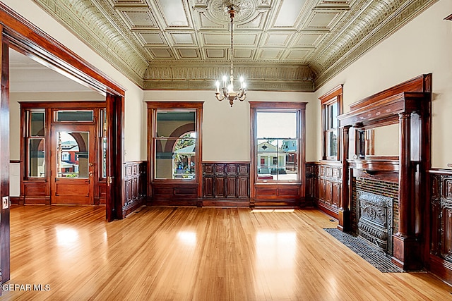 entrance foyer featuring a chandelier, crown molding, and light wood-type flooring