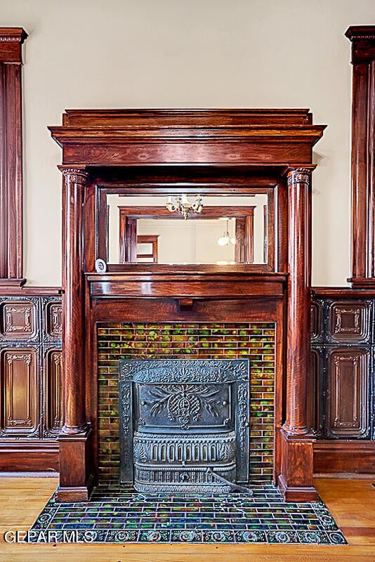 details featuring hardwood / wood-style flooring and a tile fireplace