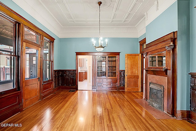 unfurnished living room featuring an inviting chandelier and hardwood / wood-style flooring