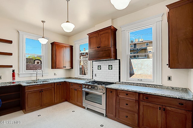 kitchen featuring a wealth of natural light, high end stove, sink, and decorative light fixtures