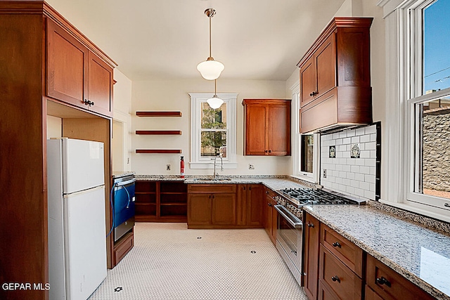 kitchen with stainless steel stove, white refrigerator, pendant lighting, tasteful backsplash, and light tile floors