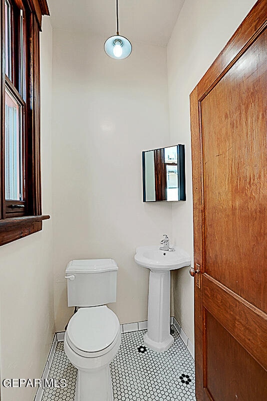 bathroom featuring tile flooring and toilet