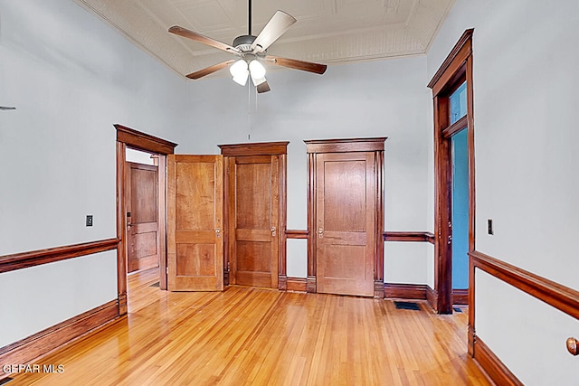 unfurnished bedroom with a high ceiling, light wood-type flooring, and ceiling fan