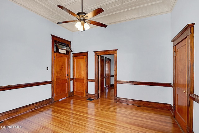 unfurnished room with a towering ceiling, light wood-type flooring, and ceiling fan