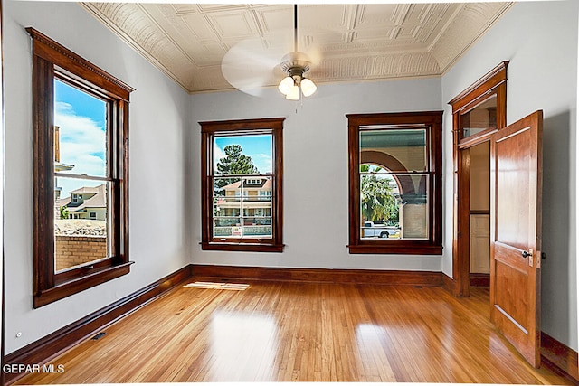 unfurnished room with ceiling fan, a healthy amount of sunlight, and wood-type flooring