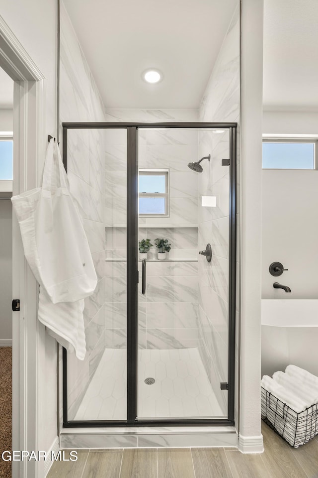 bathroom featuring a shower with door and a healthy amount of sunlight