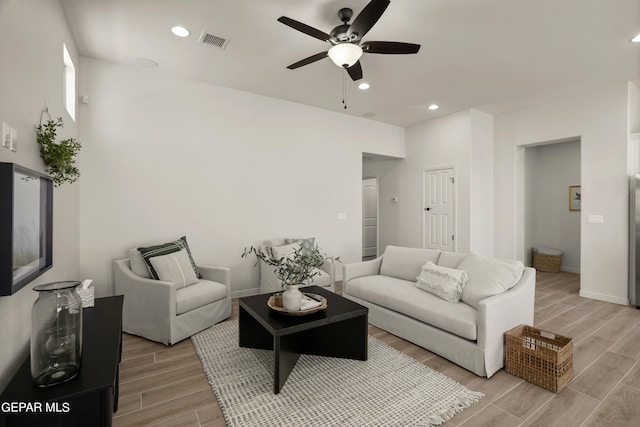 living room with light wood-type flooring and ceiling fan