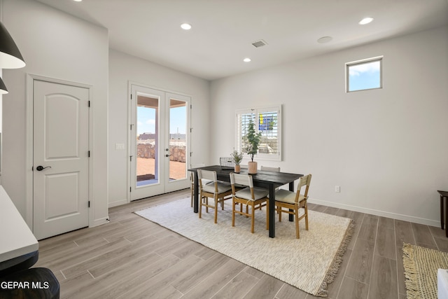 dining room with french doors and light hardwood / wood-style flooring