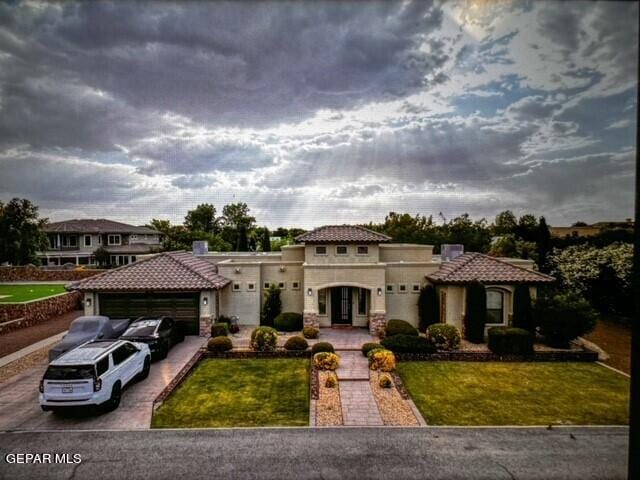 mediterranean / spanish-style house featuring a garage and a front yard