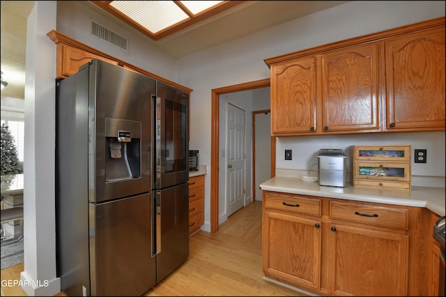 kitchen with stainless steel fridge, light hardwood / wood-style flooring, and stove