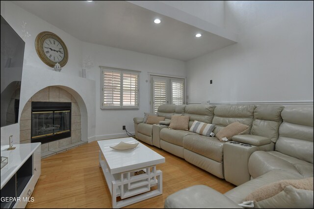 living room featuring light hardwood / wood-style floors and a tiled fireplace