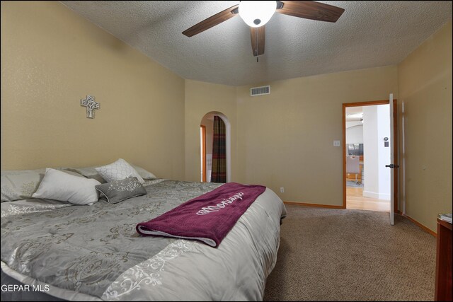 carpeted bedroom with a textured ceiling and ceiling fan