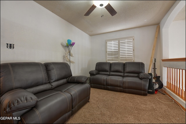 carpeted living room featuring a textured ceiling and ceiling fan