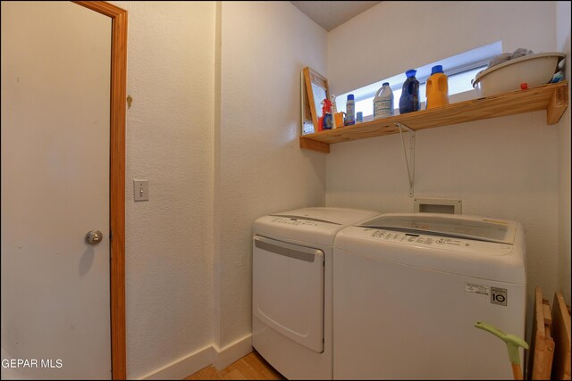 laundry room with separate washer and dryer and light wood-type flooring