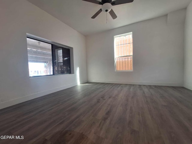 spare room featuring ceiling fan, dark hardwood / wood-style flooring, and a wealth of natural light