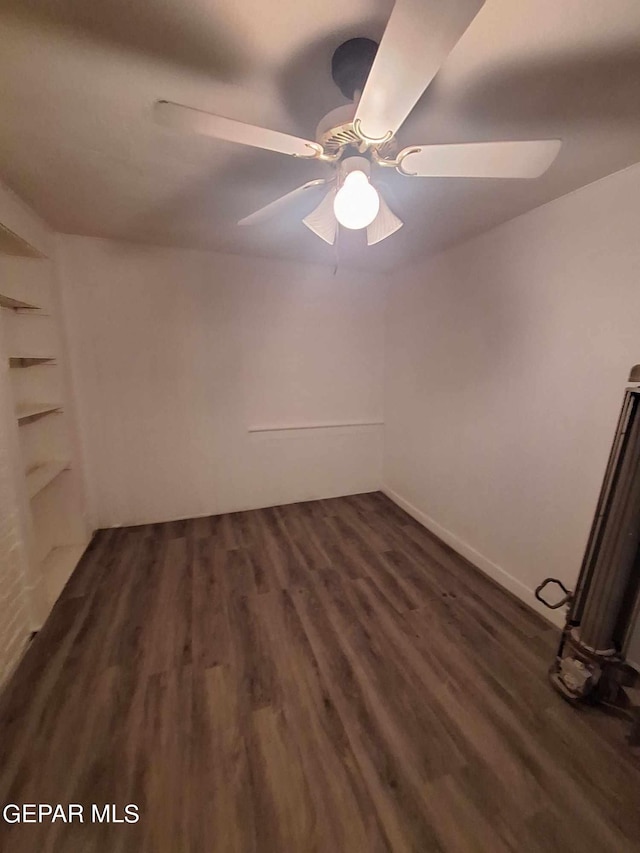 unfurnished room featuring dark wood-type flooring and ceiling fan